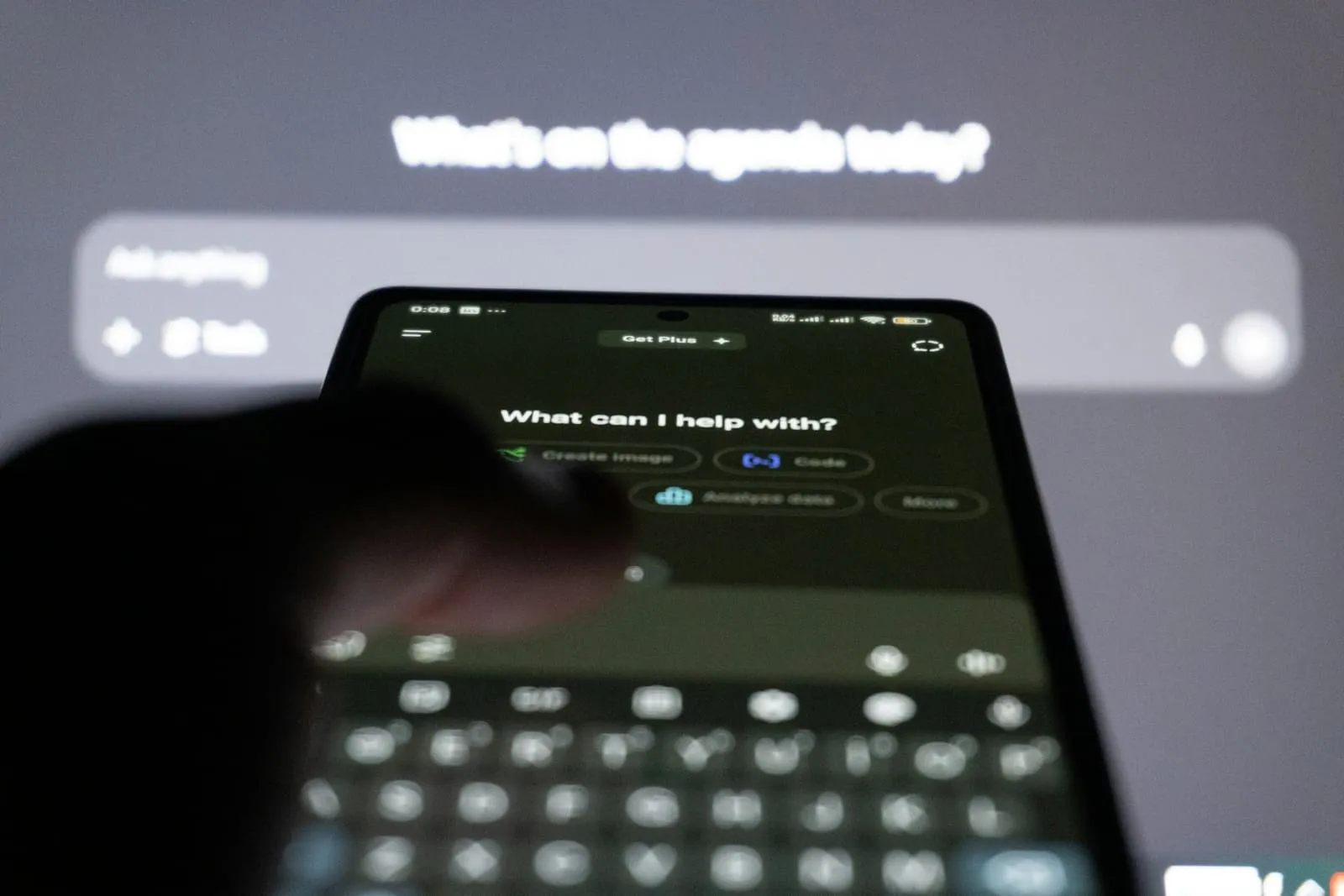 Smartphone met een AI-chatbot op het scherm voor een groot beeldscherm
